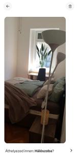 a bedroom with a bed and a window with a plant at Cozy flat near Kazinczy downtown in Budapest
