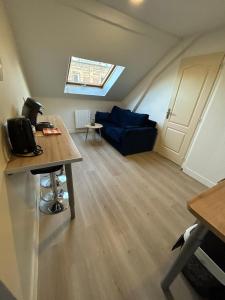 a living room with a blue couch and a window at Parfait F1, Entrée du Havre #10 in Le Havre