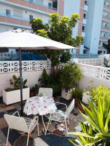 a table and chairs with an umbrella on a patio at Casa Gares in Peñíscola