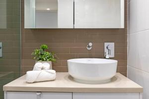 a bathroom with a large white sink in a bathroom at Waterfront Bliss - Explore Darwin's Premier Location in Darwin +32 photos