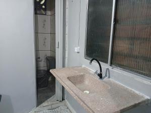 a bathroom with a sink and a window at Quarto próximo ao Inpa e Ufam in Manaus