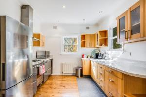 una cucina con mobili in legno e un frigorifero in acciaio inossidabile di Charming Moutain Cottage -Pet Friendly a Blackheath