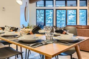 einem Holztisch mit Tellern und Besteck in der Unterkunft 24B Powder Run condo in Park City