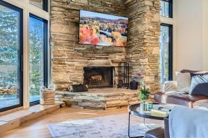 ein Wohnzimmer mit einem Steinkamin und einem Flachbildfernseher in der Unterkunft 24B Powder Run condo in Park City