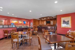 a restaurant with tables and chairs and a bar at Comfort Suites Greenwood in Greenwood