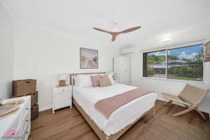 ein weißes Schlafzimmer mit einem Bett und einem Fenster in der Unterkunft Kamboola 5 Beach Breeze in South Mission Beach