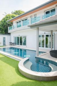 a swimming pool in front of a house at Luxury 4 Bedroom Beach House in Ban Saiyuan (1)