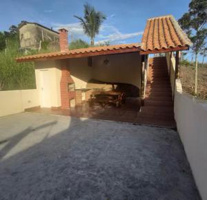 uma pequena casa com um pátio e uma mesa em House Salles em São Sebastião