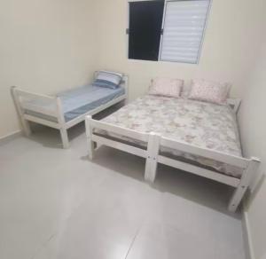 um quarto com 2 camas e uma televisão em House Salles em São Sebastião