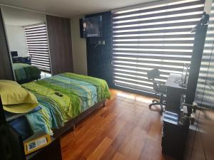 a bedroom with a bed and a desk and a window at Elegante depa de 2 dormitorios calacoto entre calle 9 y 10 in La Paz