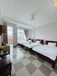 two beds in a bedroom with a checkered floor at Amy Hotel Hue in Hue +36 photos