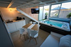 a bathroom with a tub and a table and chairs at Villa Bono Jacuzzi & Spa in Saint-Laurent-du-Var
