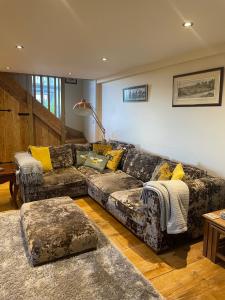 ein Wohnzimmer mit einem Sofa und gelben Kissen in der Unterkunft Meagill Cottage Sleeps 4 with Hot Tub & Parking in Otley