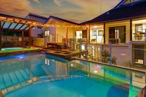 a swimming pool in front of a house at Kings Coastal Haven in Caloundra