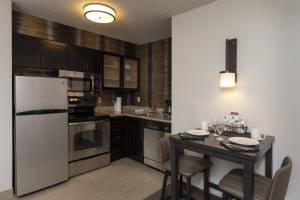 Una cocina con una mesa y un refrigerador blanco. en Residence Inn Durango Downtown, en Durango