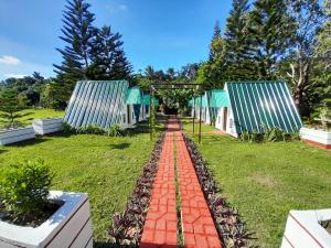 a garden with a red brick walkway at Villa Karensa Farm in General Emilio Aguinaldo
