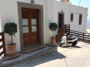 a scooter parked next to a building with a door at Mistral-Patmos in Patmos