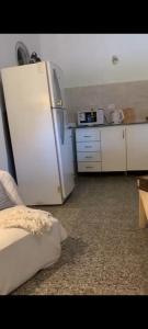 Una cocina con un refrigerador blanco en una habitación. en VIGO Apto, en Belén de Escobar