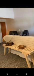 una cama de madera y una mesa con 2 celulares en VIGO Apto, en Belén de Escobar