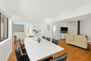 a dining room and living room with a white table and chairs at Starry Nights in Cowes