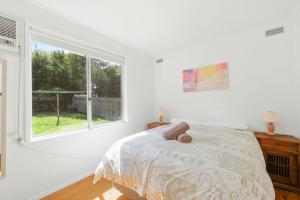 a white bedroom with a bed and a window at Starry Nights in Cowes
