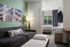 a living room with a couch and a bedroom at SpringHill Suites Nashville MetroCenter in Nashville