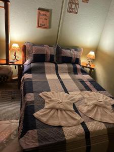 Un dormitorio con una cama con dos vestidos. en Pousada Chácara Pacheco, en Visconde De Maua