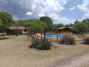 una valla alrededor de una piscina en un patio en La Almenara Lodge, en Villa General Belgrano