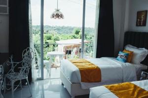 a bedroom with two beds and a balcony with a view at Our Story Boutique Hotel in Cagayan de Oro +36 photos