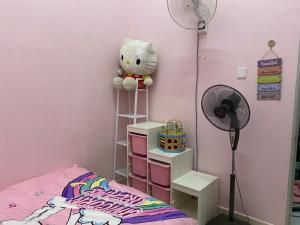 a bedroom with a pink wall with a teddy bear on a ladder at Bestari Bliss Homestay MELAYU ONLY in Bemban +2 photos