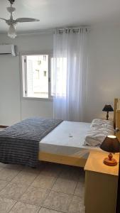 En eller flere senge i et værelse på Espaçoso 1 d perto do mar com vaga