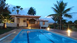 a villa with a swimming pool in front of a house at Nest 1 in Delfinópolis