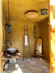 a room with a sink and a ladder and a mirror at Nest 1 in Delfinópolis