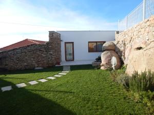 a house with a stone wall and a yard at Casa de Campo das Sécias in Vilas Boas