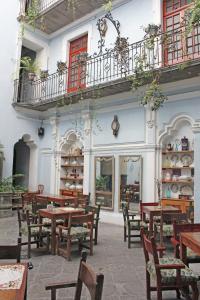 un restaurante con mesas y sillas de madera y un balcón en Hotel Boutique Casa de la Palma, en Puebla