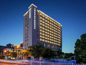 上海Shanghai Hongqiao Yankuang Tulip Hotel的一座侧面有标志的高楼