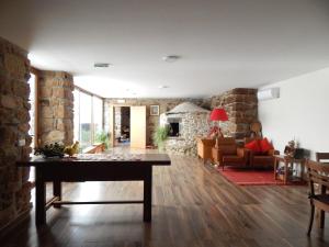 a living room with a table and a stone wall at Casa de Campo das Sécias in Vilas Boas