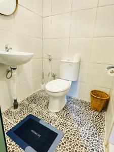 een badkamer met een wastafel, een toilet en een weegschaal bij Gatep Tree in Uluwatu