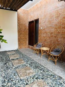 twee stoelen en een tafel op een patio bij Gatep Tree in Uluwatu