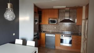una cucina con armadi in legno e piano cottura. di Residencial Torres Roma a Tarragona