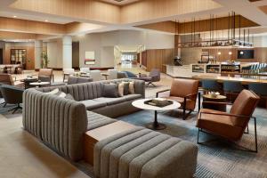 a hotel lobby with couches and tables and a kitchen at Sheraton Imperial Hotel Raleigh-Durham Airport at Research Triangle Park in Durham