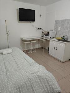 una camera con letto e scrivania con forno a microonde di Capriche Departamentos - Monoambientes a Río Gallegos