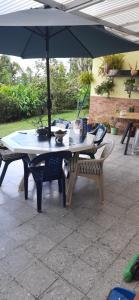 a table and a bench under an umbrella at Casa para ferias manizales in Manizales