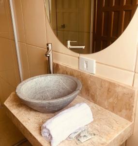 a sink in a bathroom with a mirror at Flats Santana Apartamento a 2km do centro, com garagem gratuita, a combinar in Ouro Preto