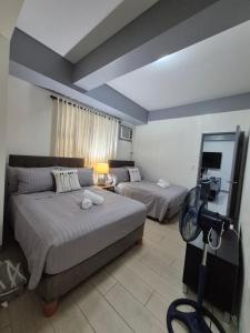 Una habitación con dos camas y un sofá y un espejo. en 101newport Condotel Near NAIA T3, en Manila 9 fotos más