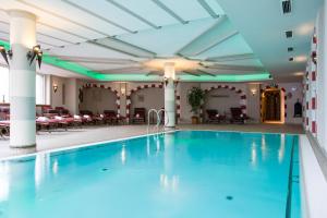 a pool in the lobby of a hotel with tables and chairs at Alte Schmiede Hiltpolt in Seefeld in Tirol