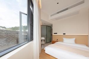 Postelja oz. postelje v sobi nastanitve Phoenix Ancient City Courtyard Hotel凤凰古城庭院酒店