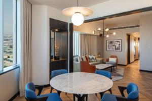 a living room with a table and chairs at Sheraton Mall of the Emirates Hotel, Dubai in Dubai
