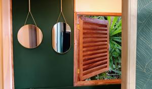 two mirrors on a green wall next to a window at The View - Jungle Lodges - Port Barton in San Vicente