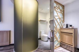 a bathroom with a shower and a toilet at Cozylife Hotel Canal in Hangzhou
